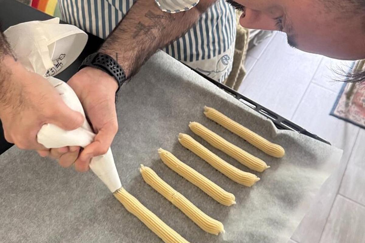 una persona sta preparando degli hot dog crudi su una griglia