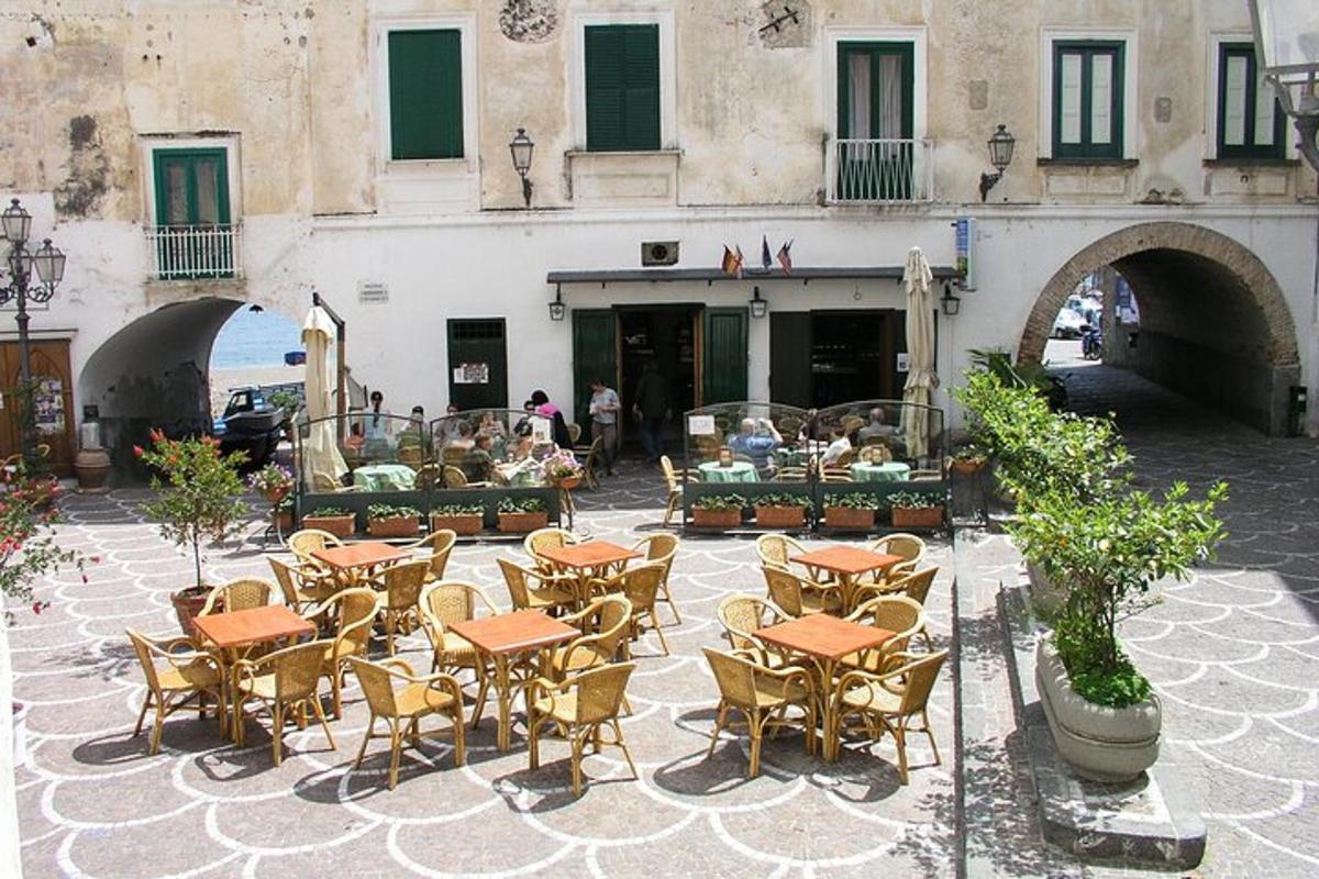 eine Terrasse mit Tischen und Stühlen vor einem Gebäude