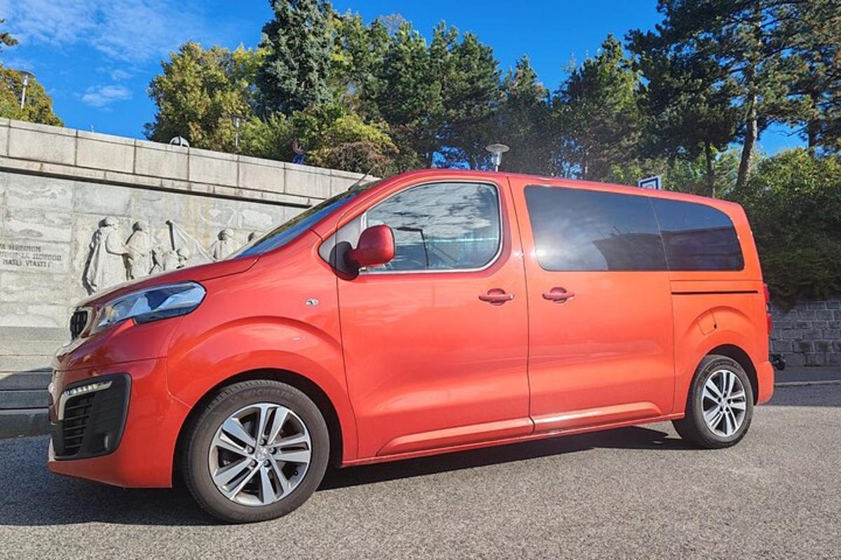 mažas raudonas automobilis, pastatytas automobilių stovėjimo aikštelėje