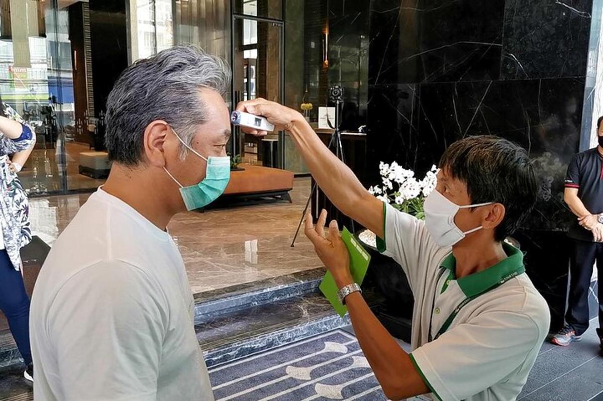 a man taking a picture of a woman wearing a mask