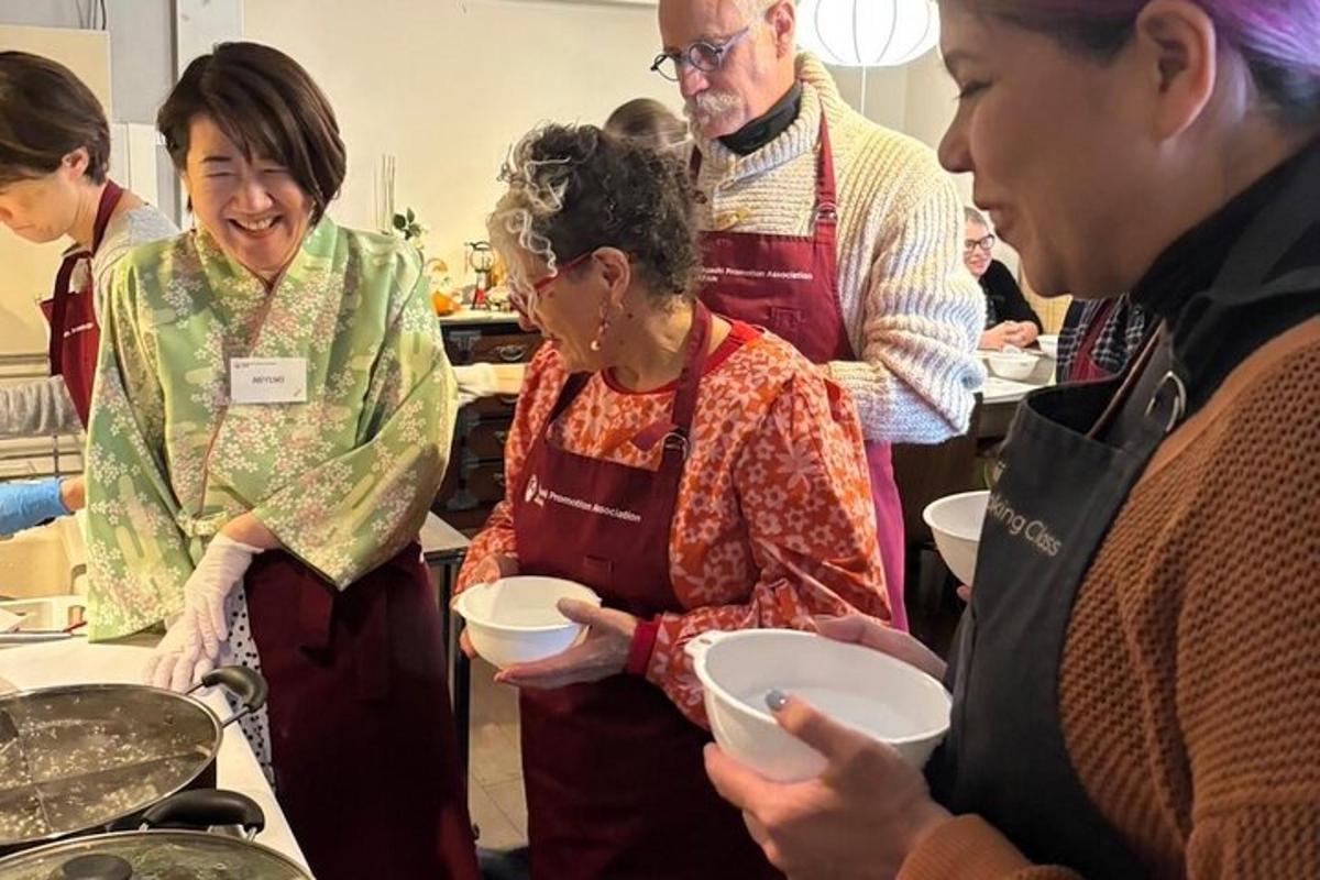 un gruppo di persone in piedi in una cucina che prepara il cibo