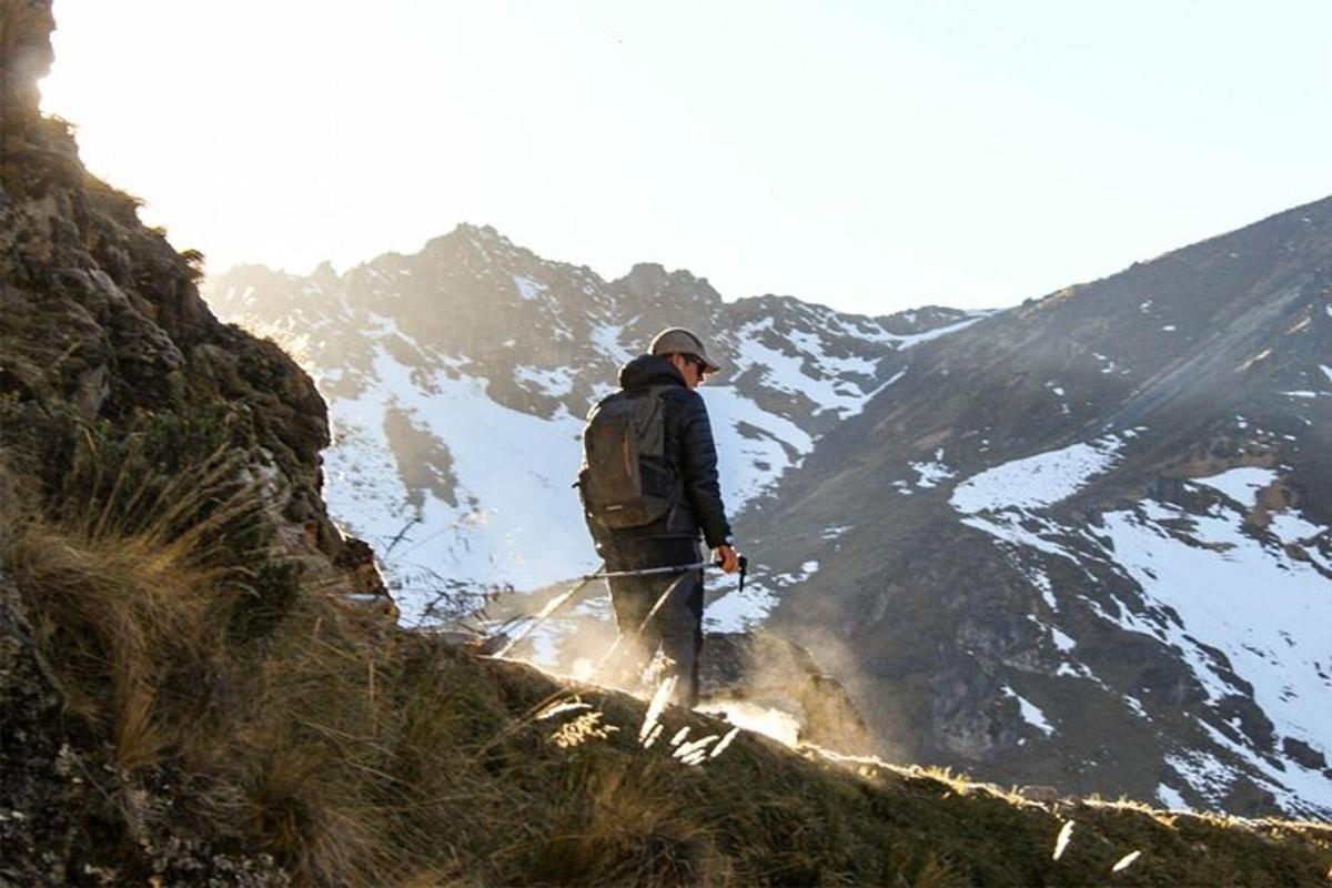 un uomo con uno zaino in piedi sulla cima di una montagna