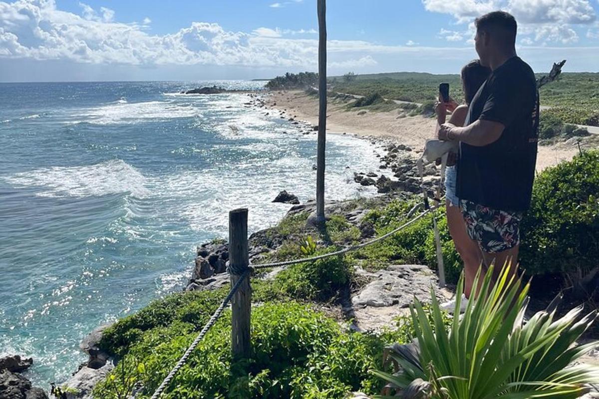 muž držící dítě a dívající se na oceán