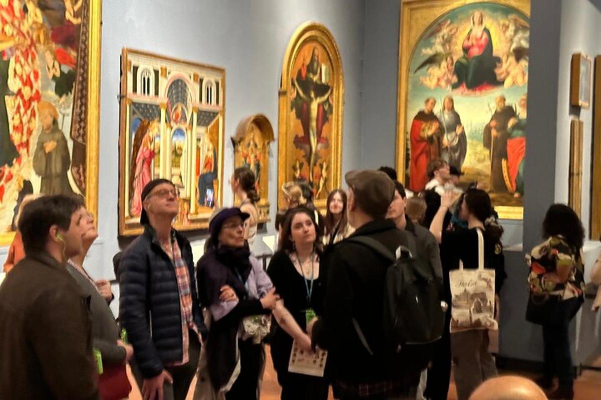 en gruppe mennesker som står i et museum og ser på malerier