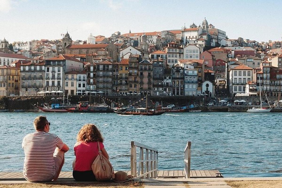 a man and woman sitting on a dock looking at the water