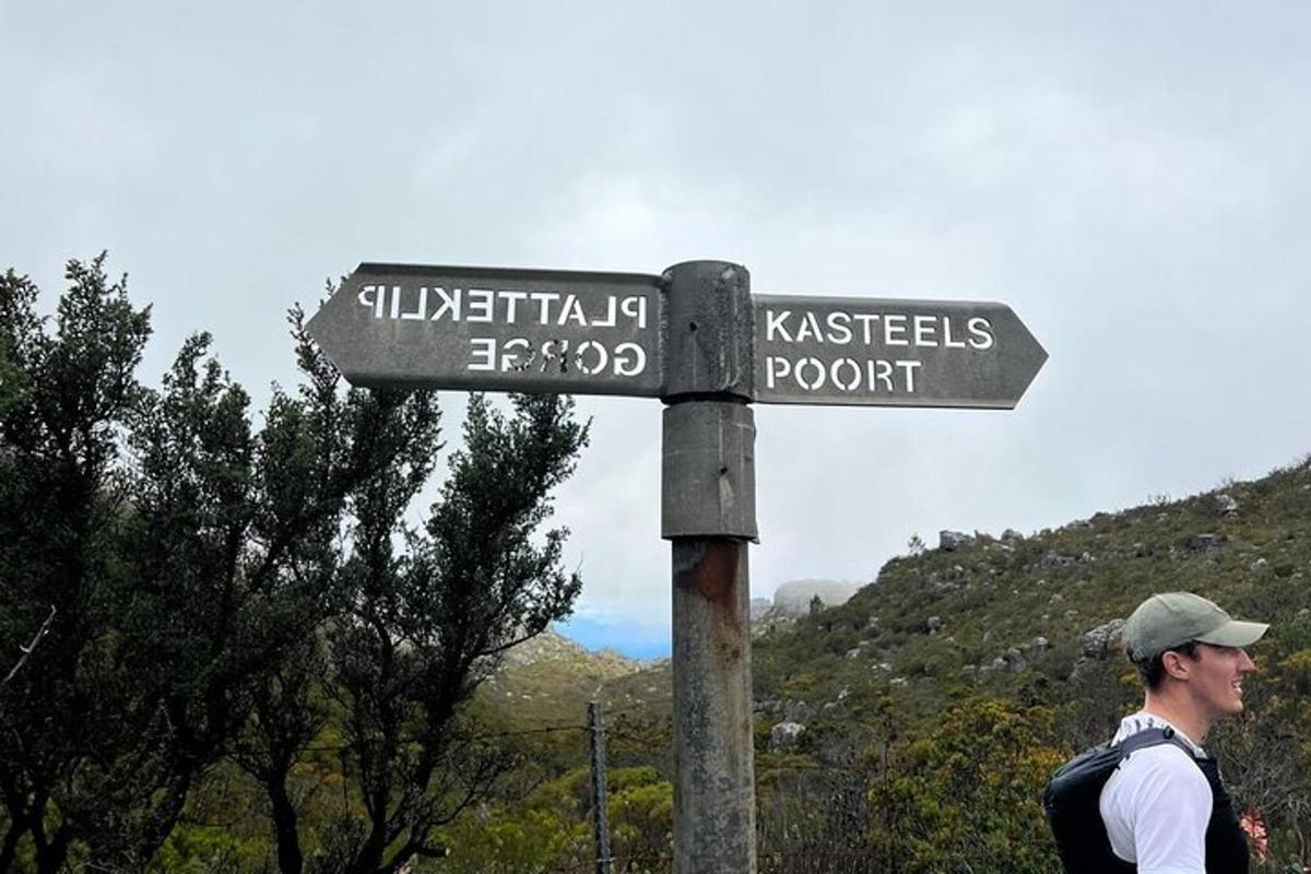 um homem está parado ao lado de uma placa de rua