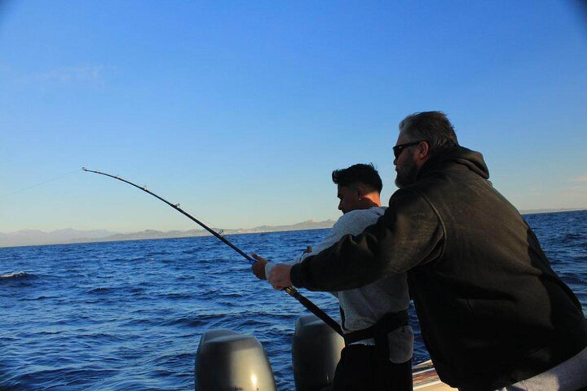 two men fishing on a boat in the water