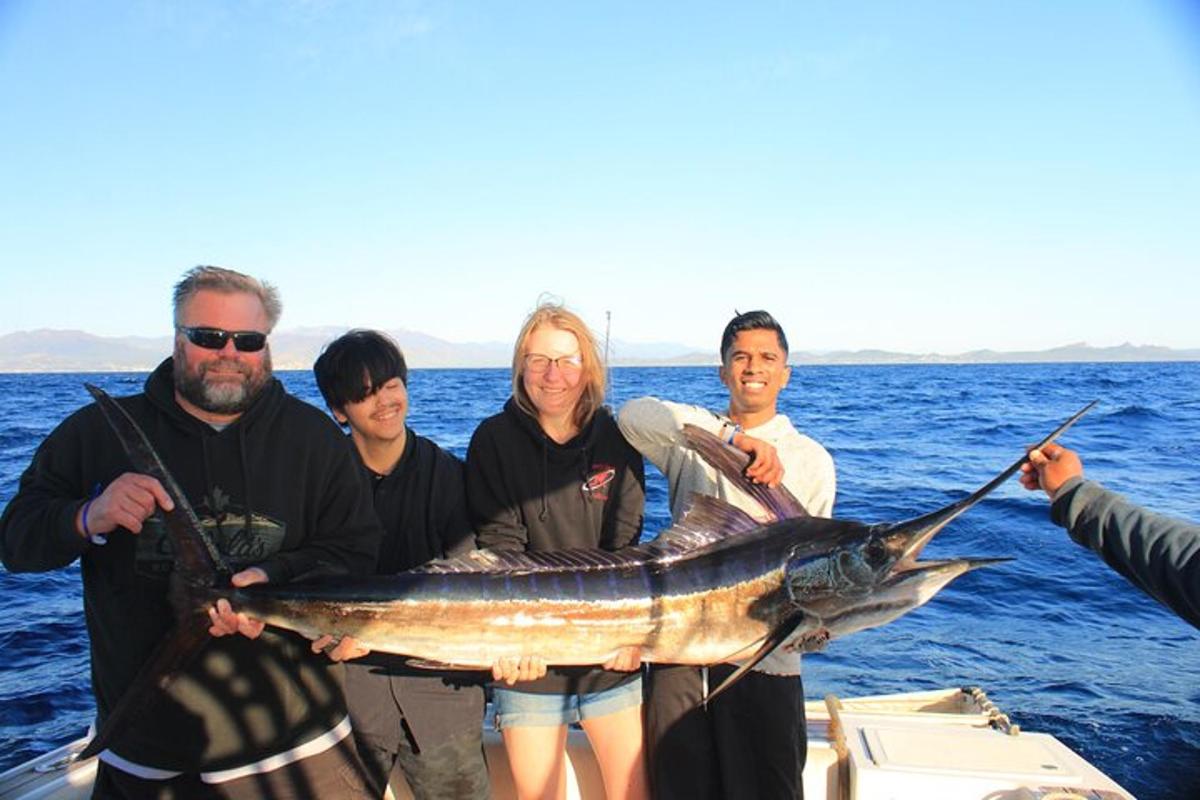a group of people holding a fish on a boat