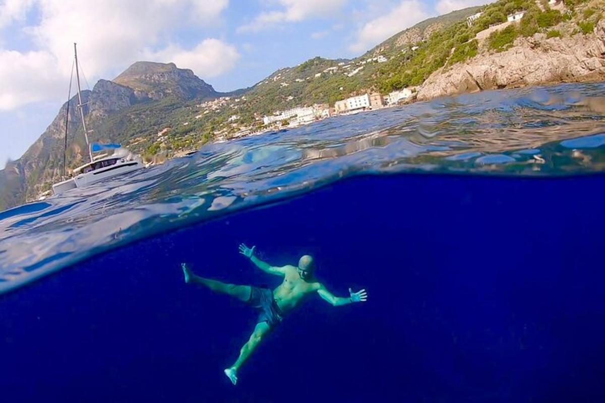 una persona che nuota nell'oceano con una barca