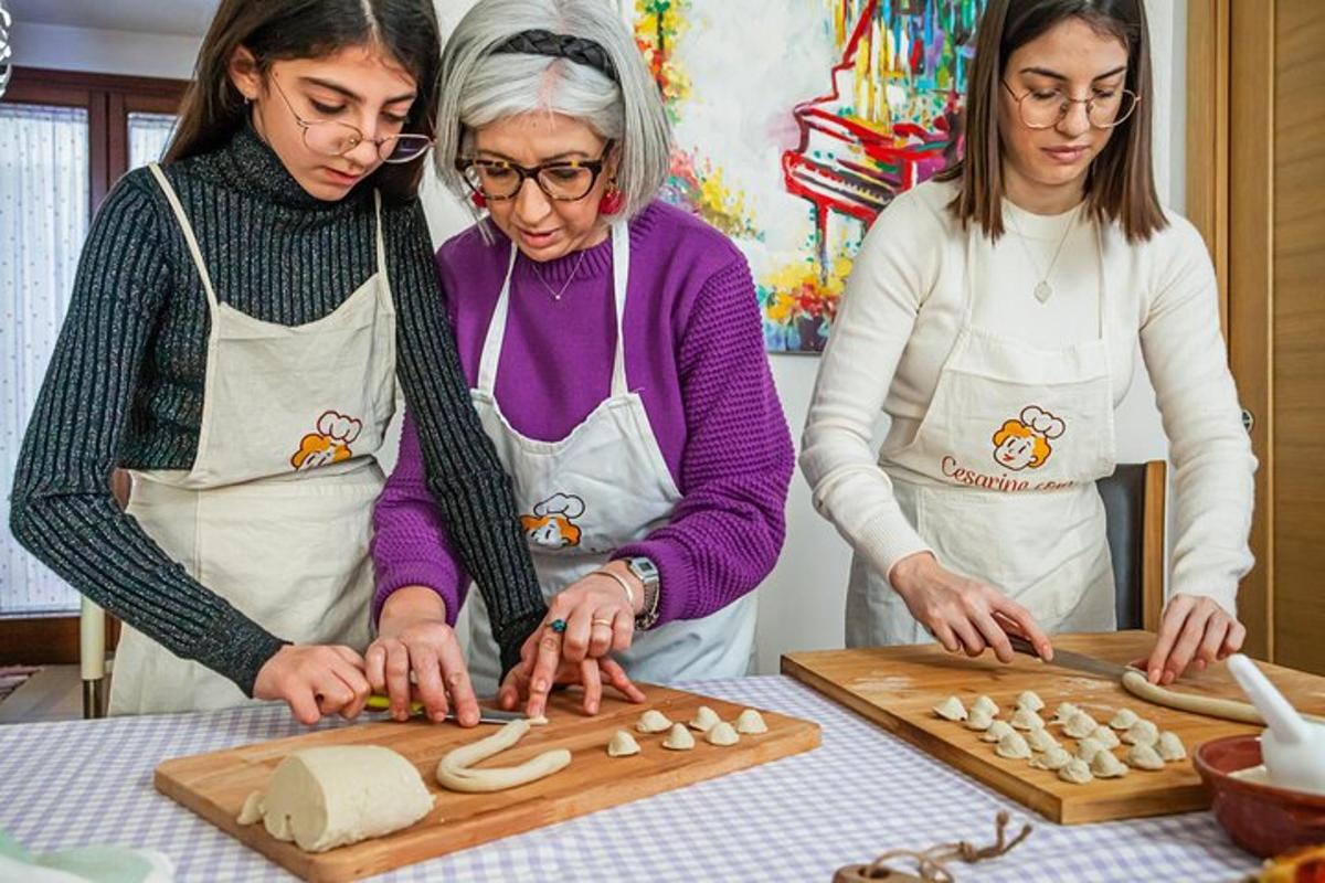 duas mulheres em uma cozinha preparando comida em uma tábua de corte