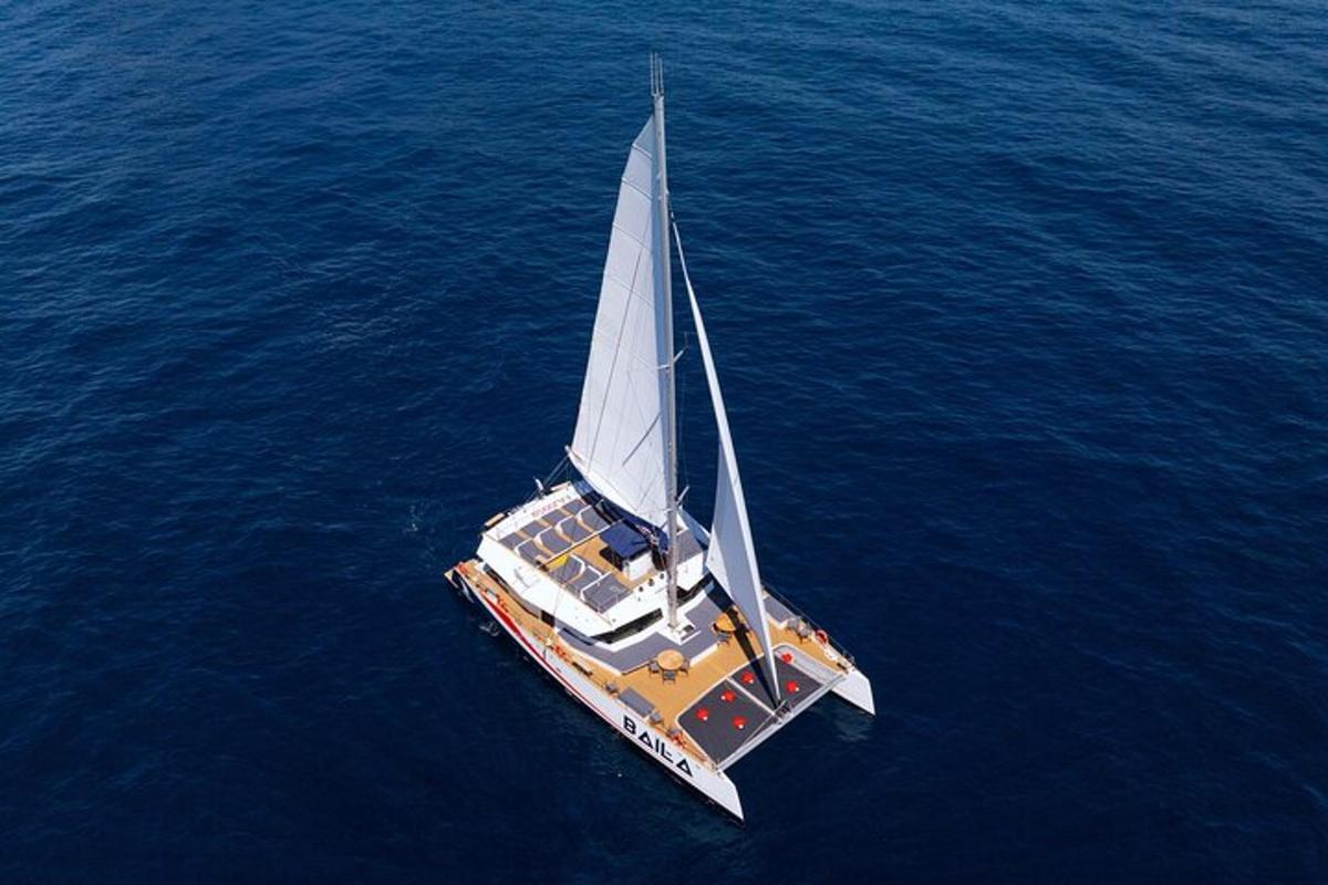 un vaixell amb una gran vela blanca a l'aigua