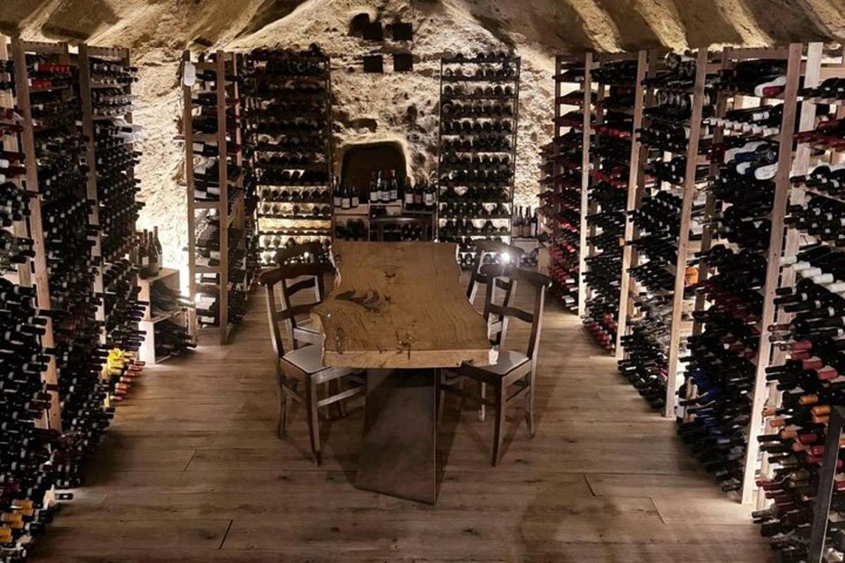 una stanza con un tavolo e un mucchio di bottiglie di vino