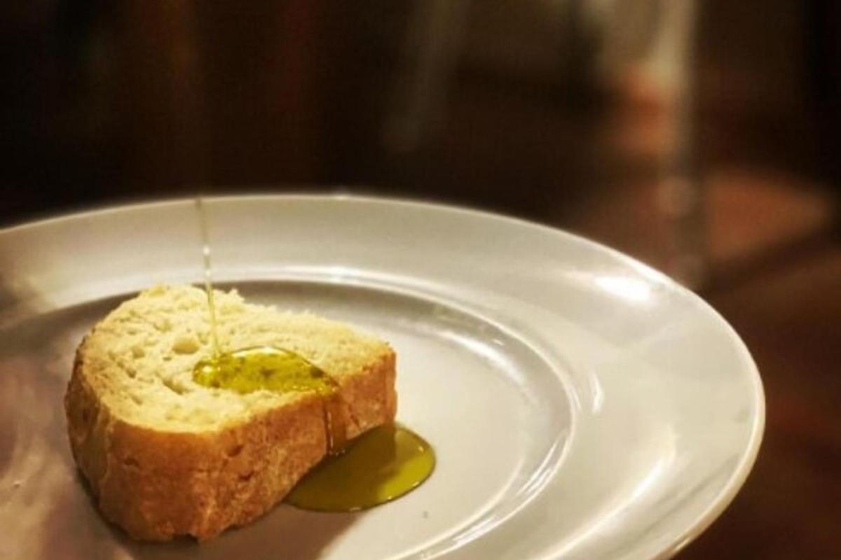 un piatto bianco con un pezzo di pane e un sottaceto