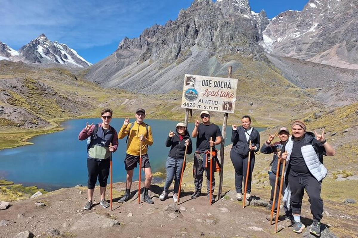 en gruppe mennesker som står ved siden av et skilt på et fjell