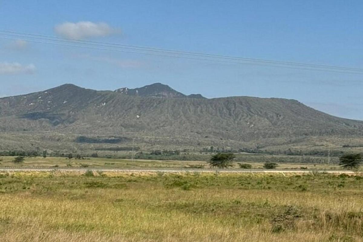 un camp amb muntanyes a la distància amb una carretera