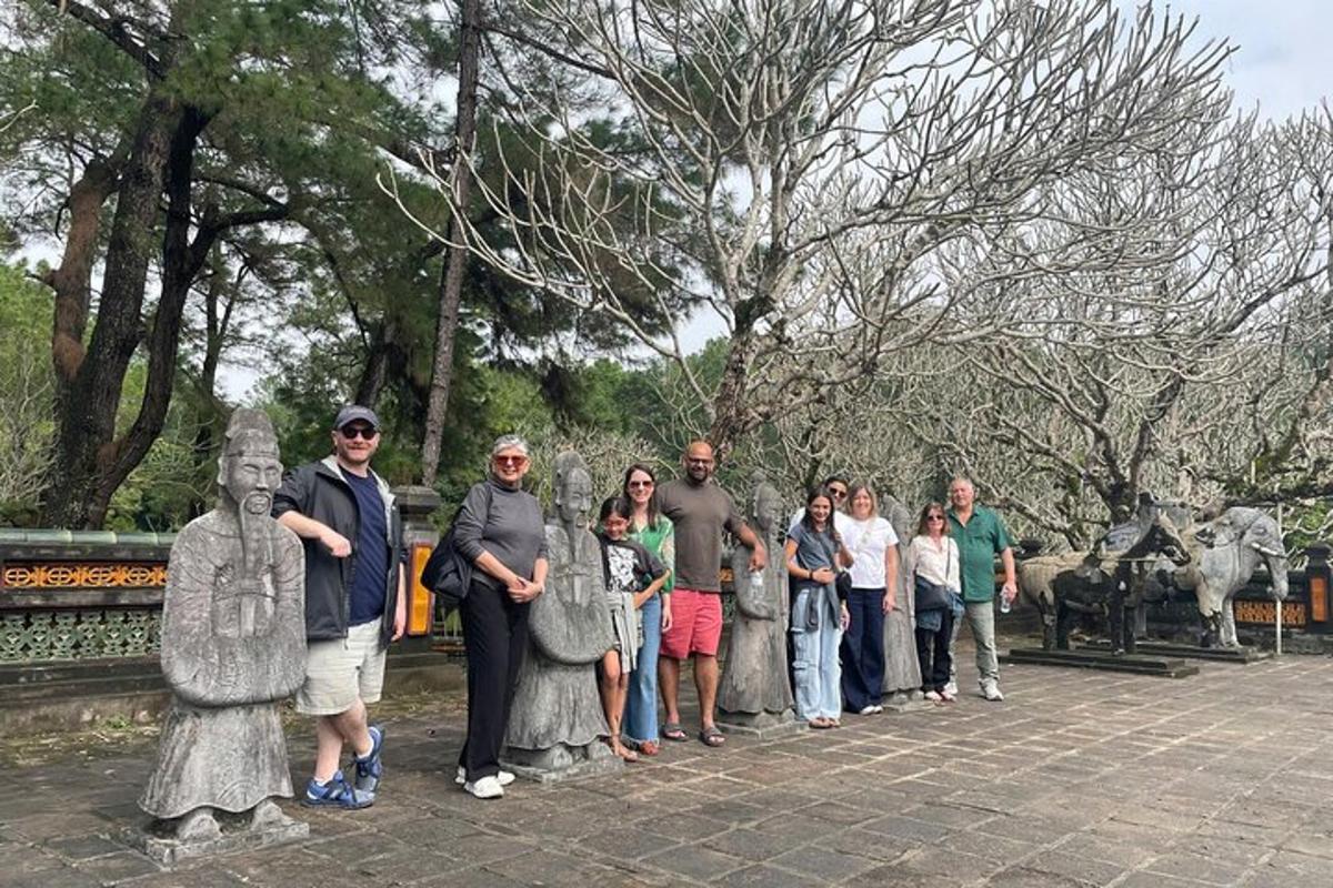 a group of people standing next to statues in a park