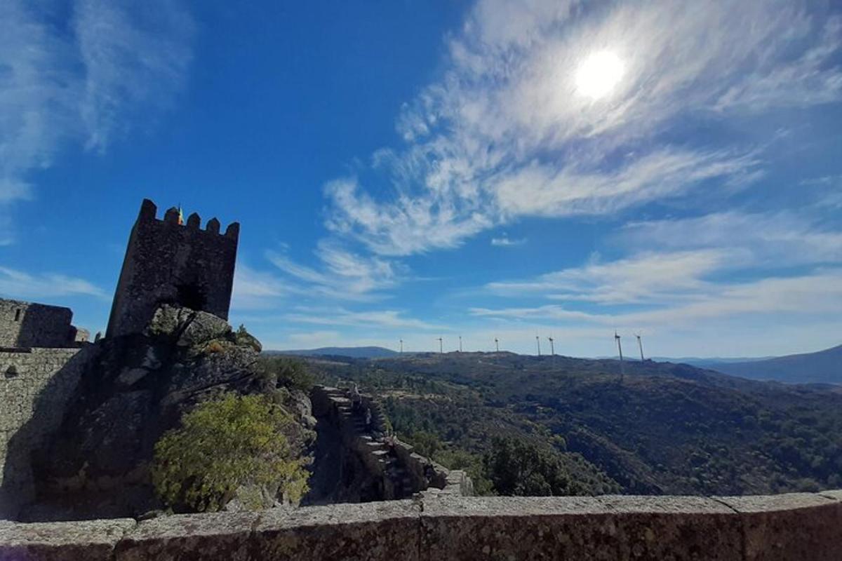 a castle on top of a mountain with the sun in the sky