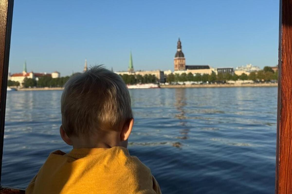 a young boy sitting on a boat in the water