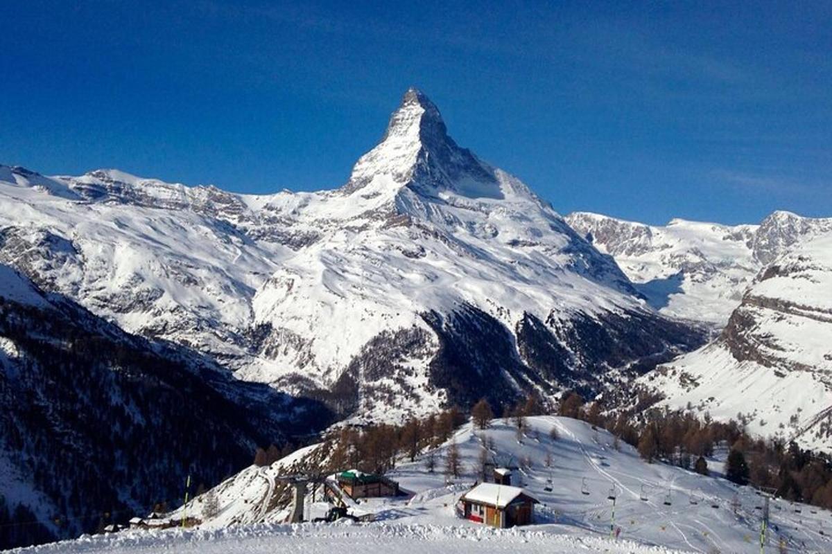 a snow covered mountain with a house in front of it