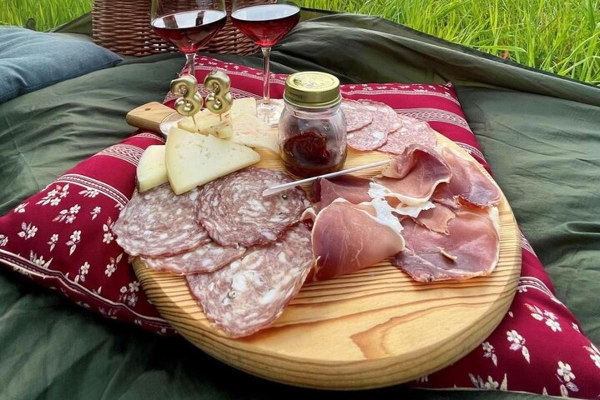Un plato de carne y queso y dos copas de vino