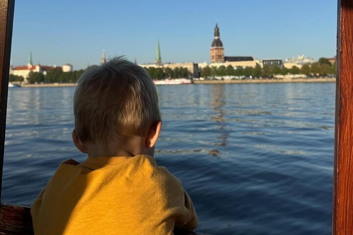 väike poiss istub paadis vees