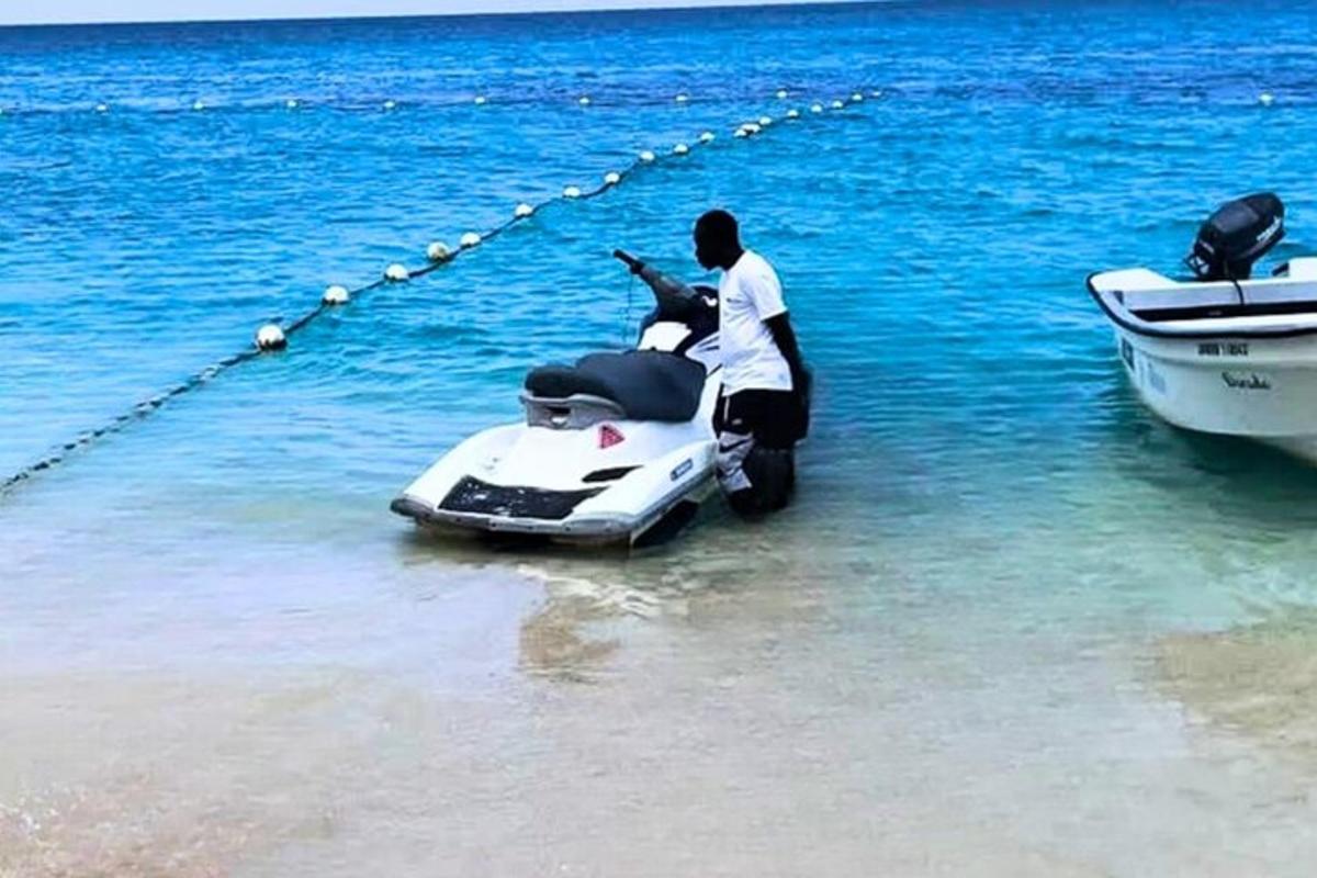 un home en una motocicleta a l'aigua al costat d'un vaixell