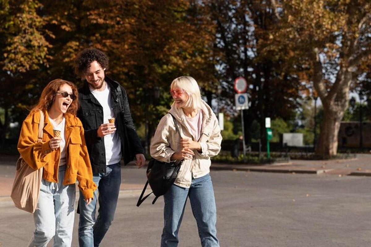 Mees ja kaks naist kõnnivad mobiiltelefonidega tänaval