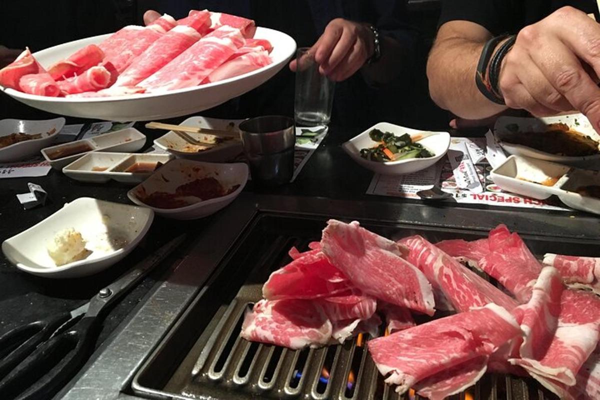Un montón de carne en una parrilla con otros alimentos.
