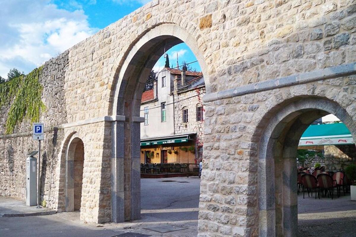 Un muro de piedra con dos arcos en una calle