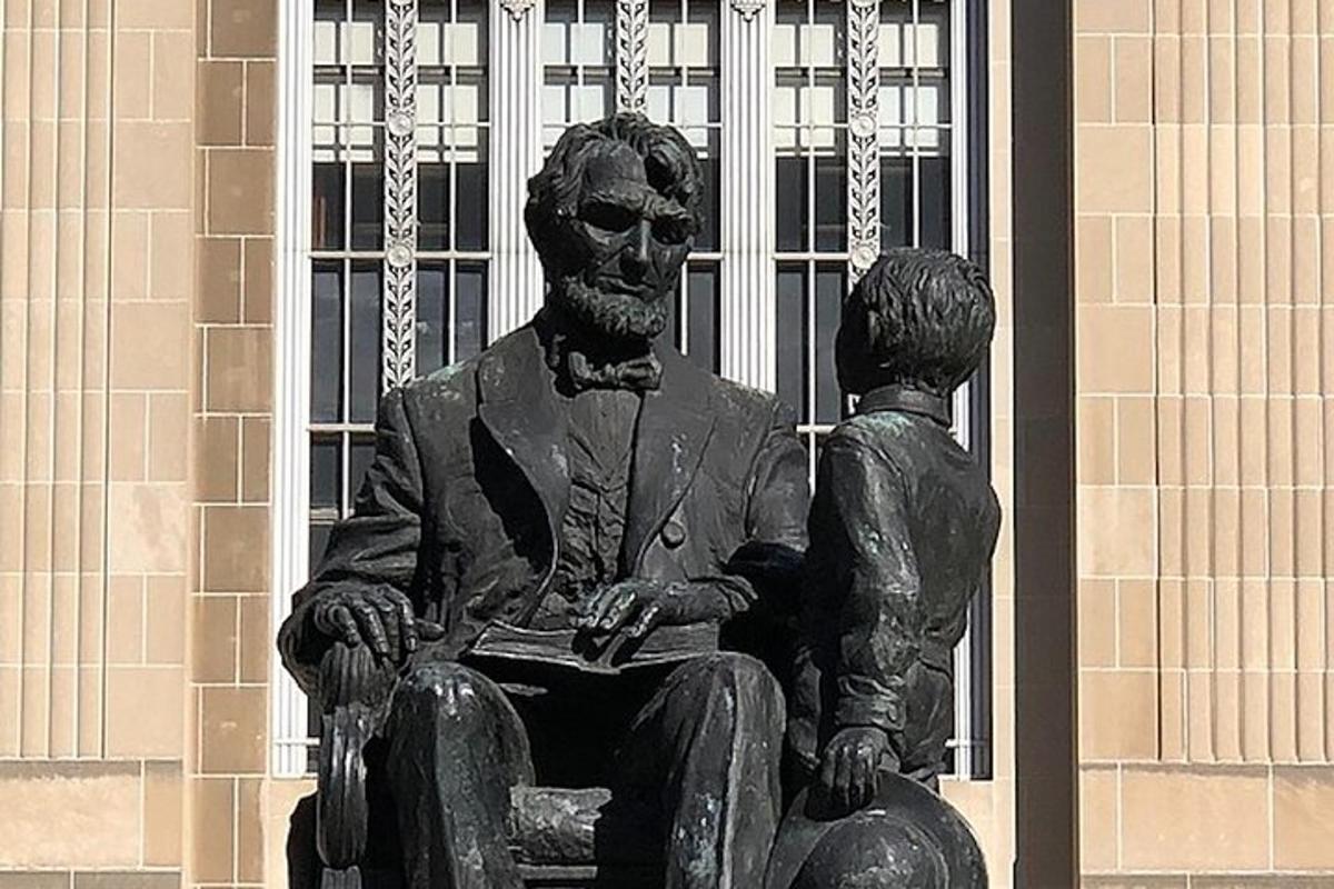 a statue of a man sitting in a swing with a child