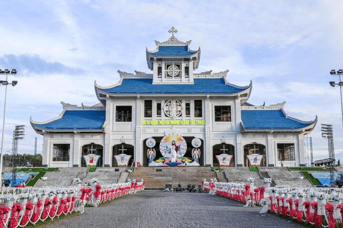 một tòa nhà lớn màu trắng có mái màu xanh