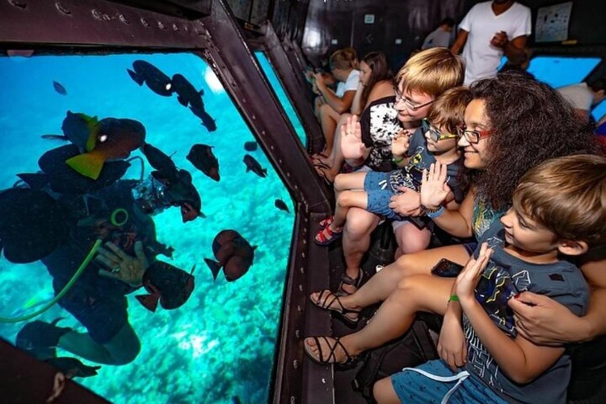 a group of people watching fish in an aquarium