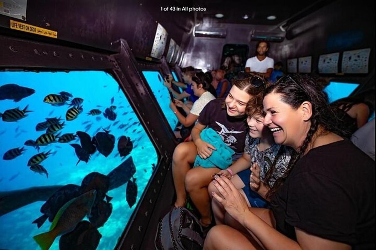 a group of people looking at fish in an aquarium
