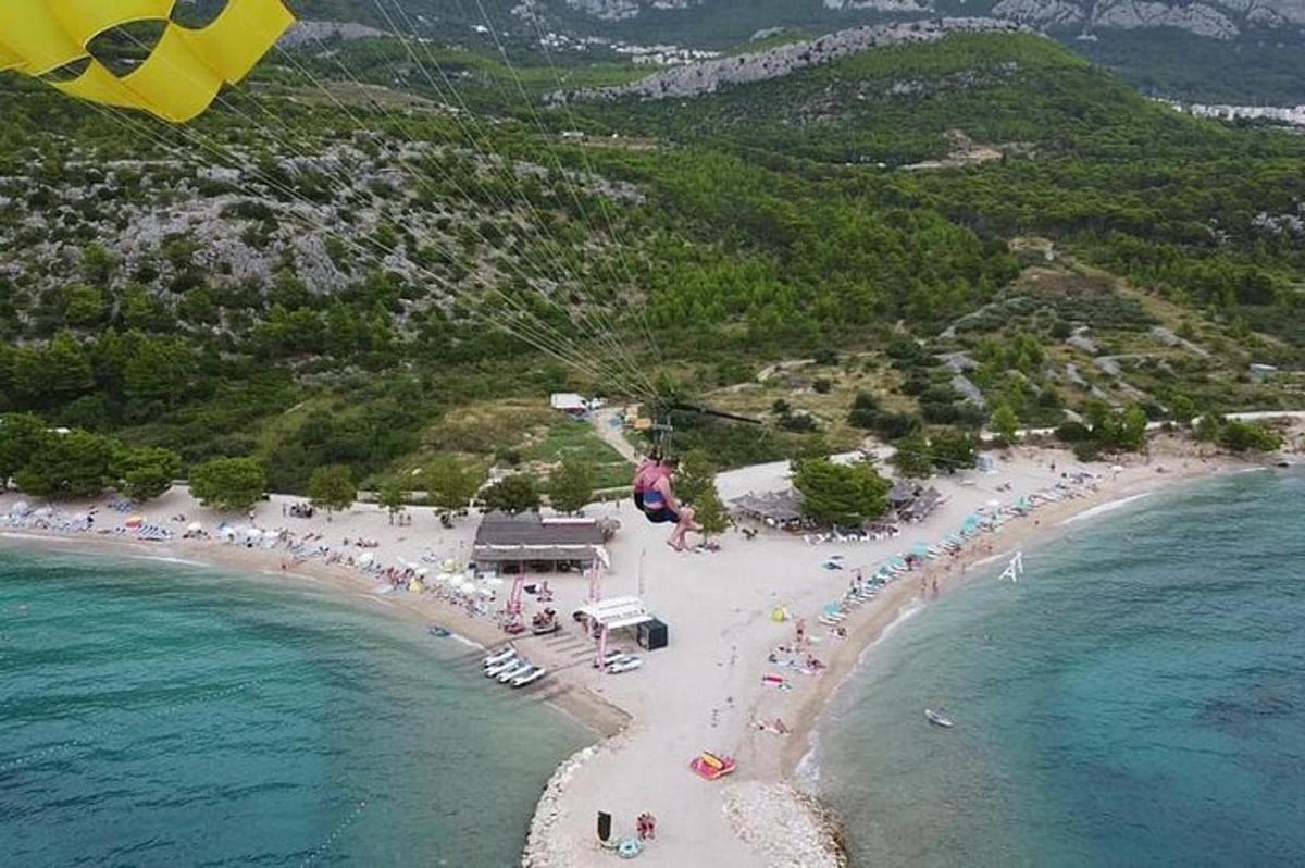 ένα άτομο που πετάει χαρταετό πάνω από μια παραλία