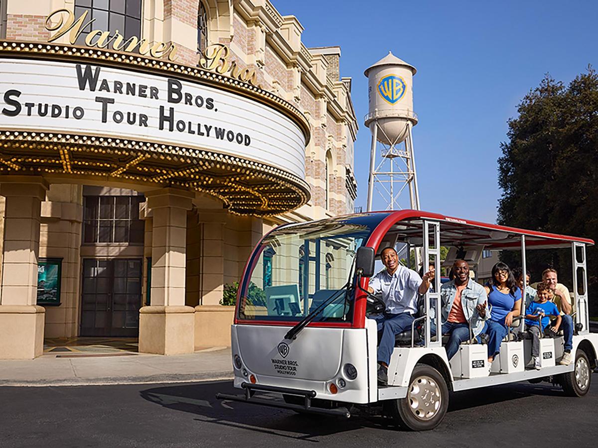 a group of people riding on a golf cart in front of a building