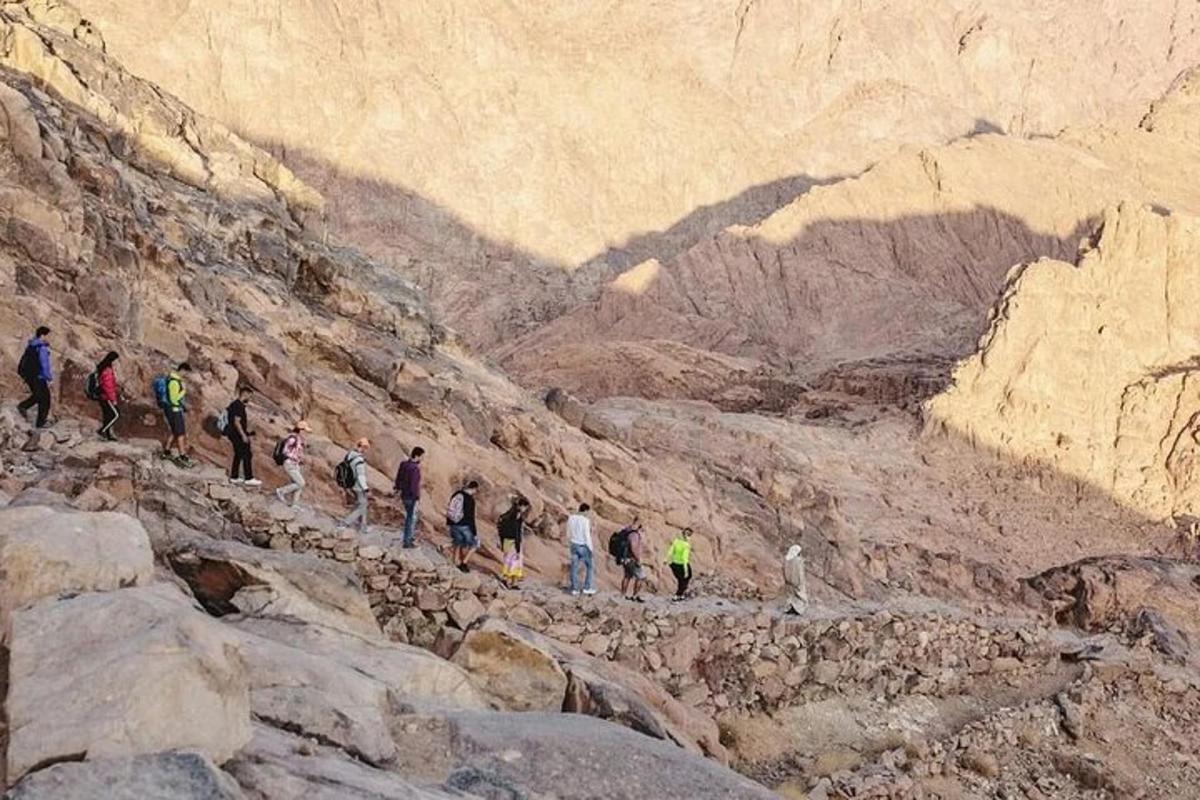 en gruppe mennesker som går opp et steinete fjell