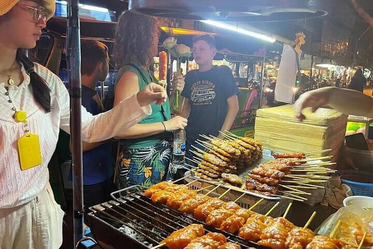 oseba, ki kuha hrano na žaru na tržnici