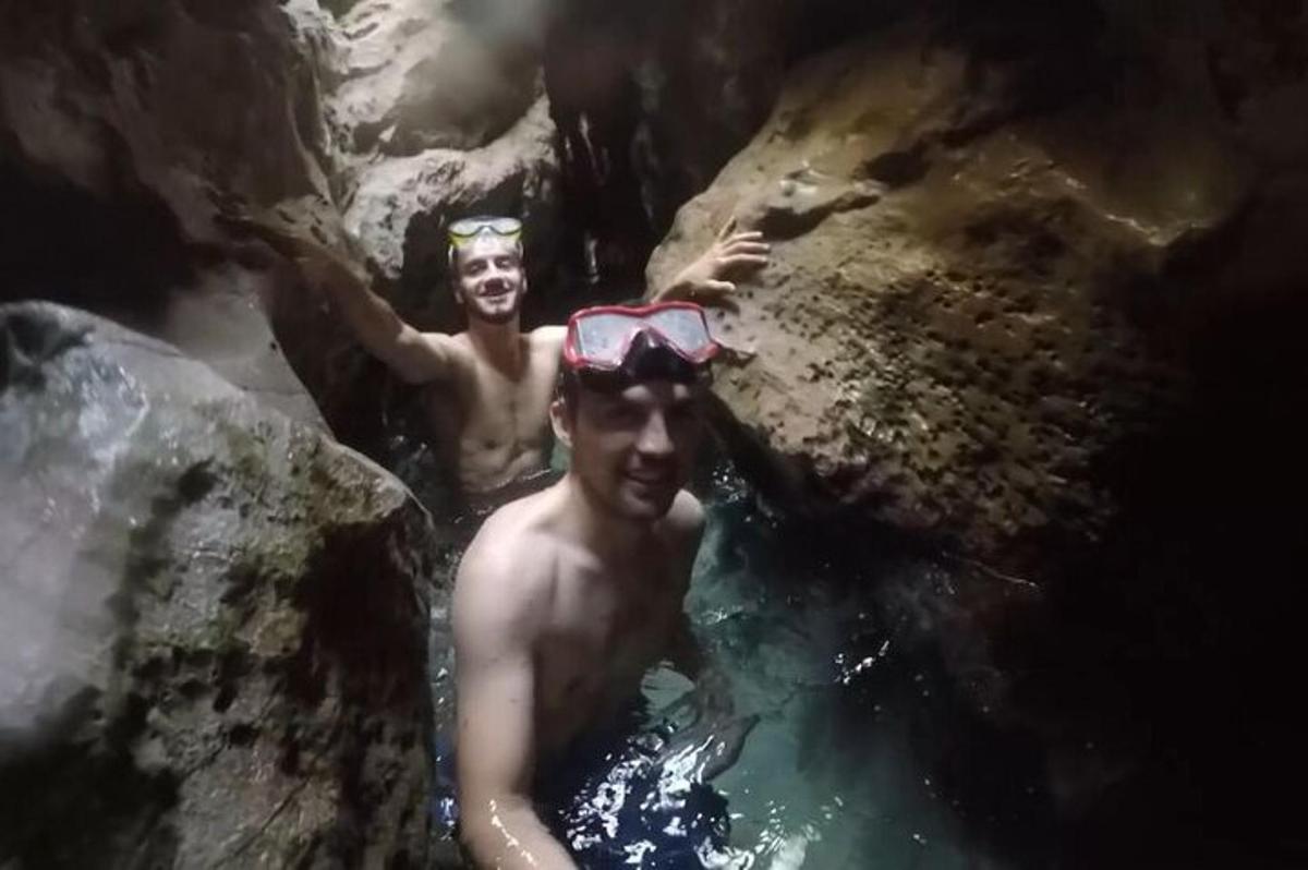 two men in the water with goggles on their heads
