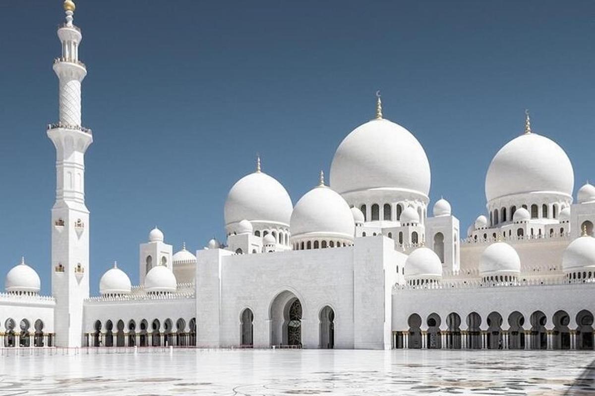 a large white mosque with domes and a minaret