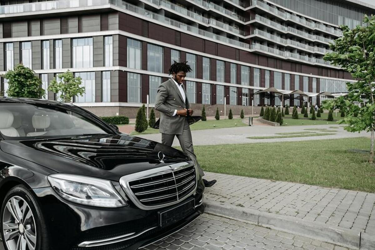 a man in a suit standing next to a car
