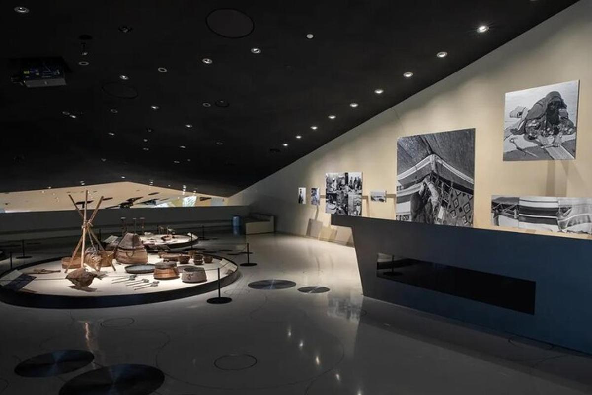 a room with a table and photographs on the wall