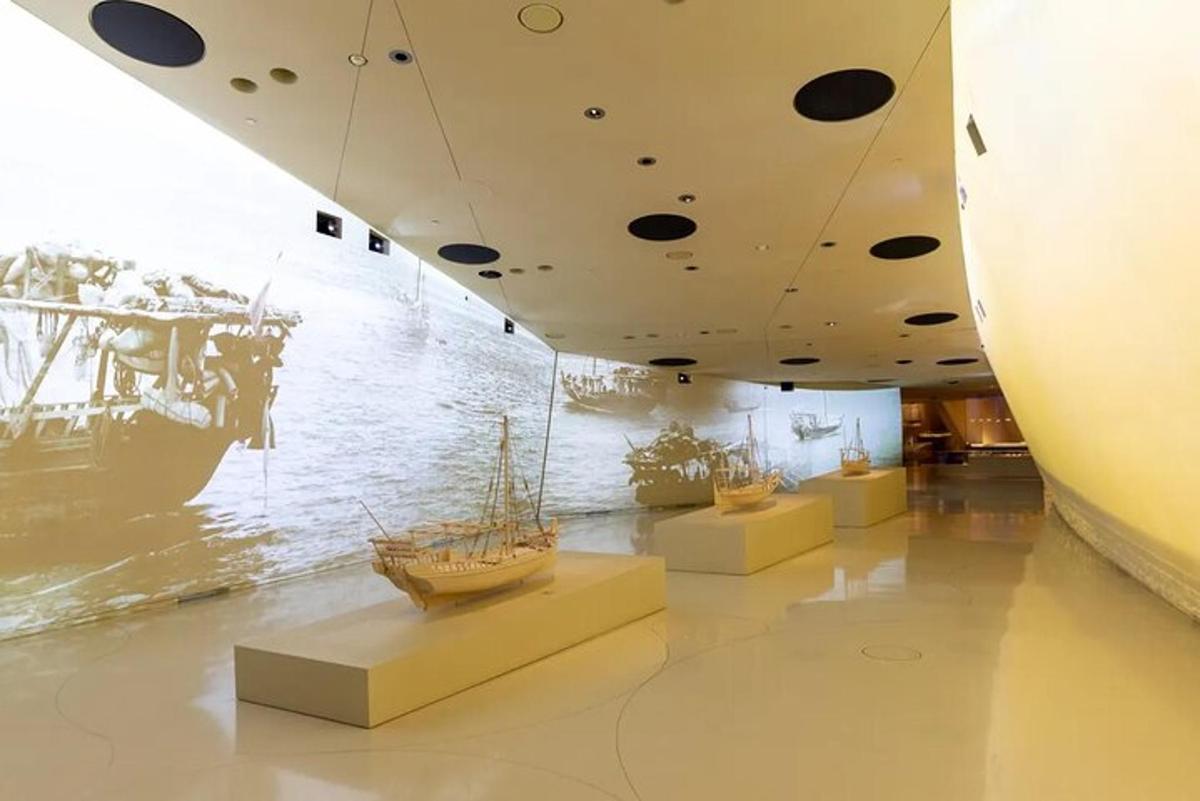 a museum exhibit with a boat on the water