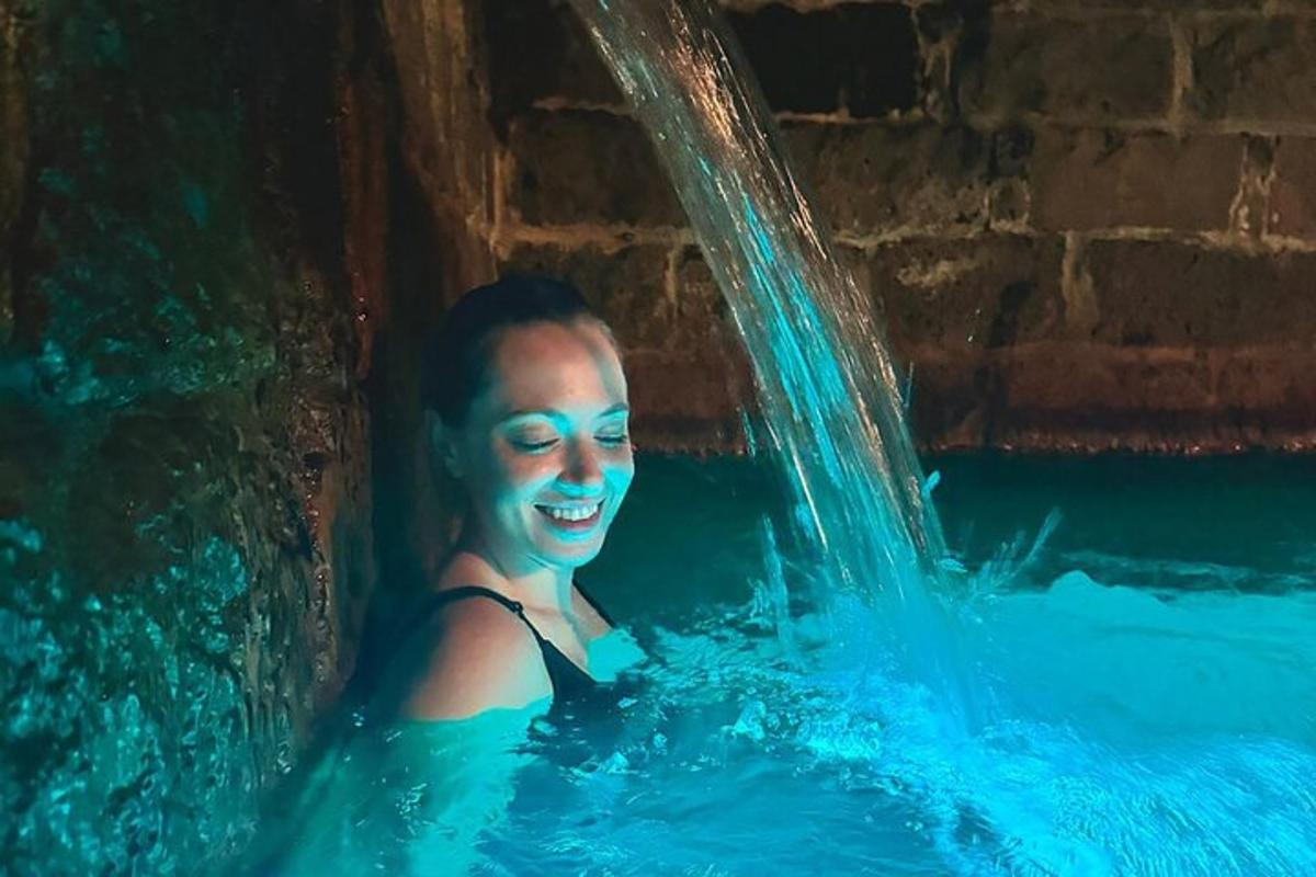 μια γυναίκα σε μια πισίνα με έναν καταρράκτη
