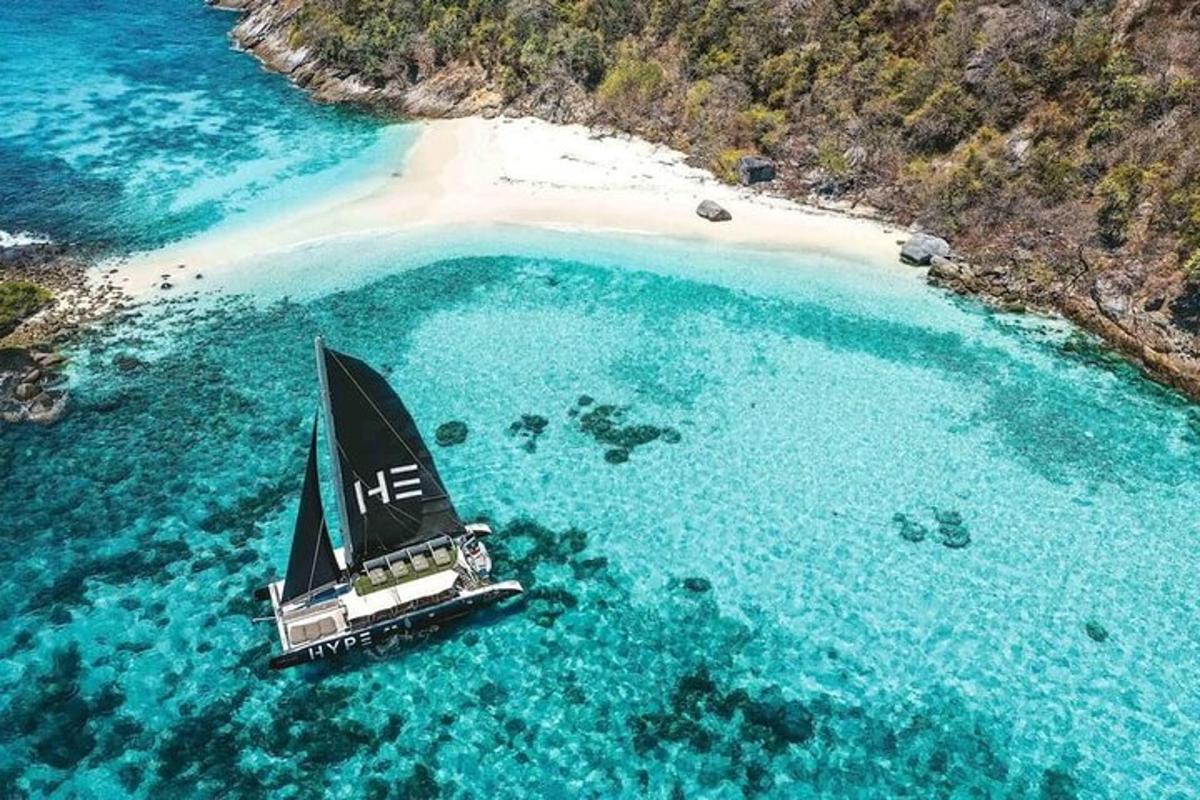 una piccola barca a vela in acqua vicino a una spiaggia