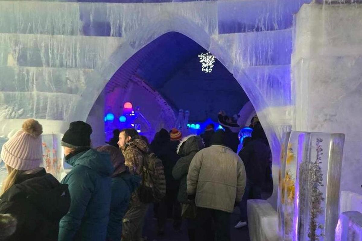 група људи који ходају кроз тунел у леденој пећини