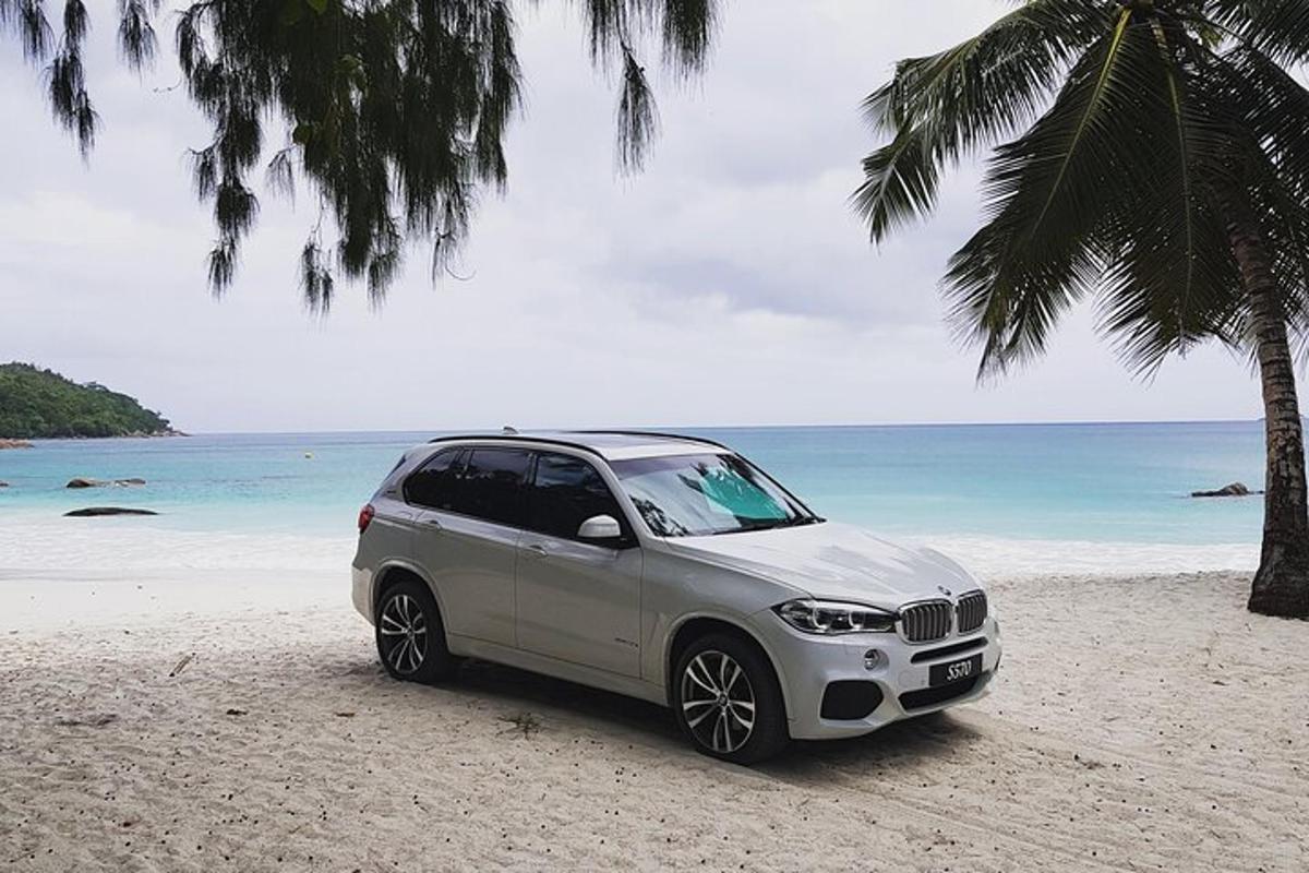 a silver car parked on a beach near the ocean