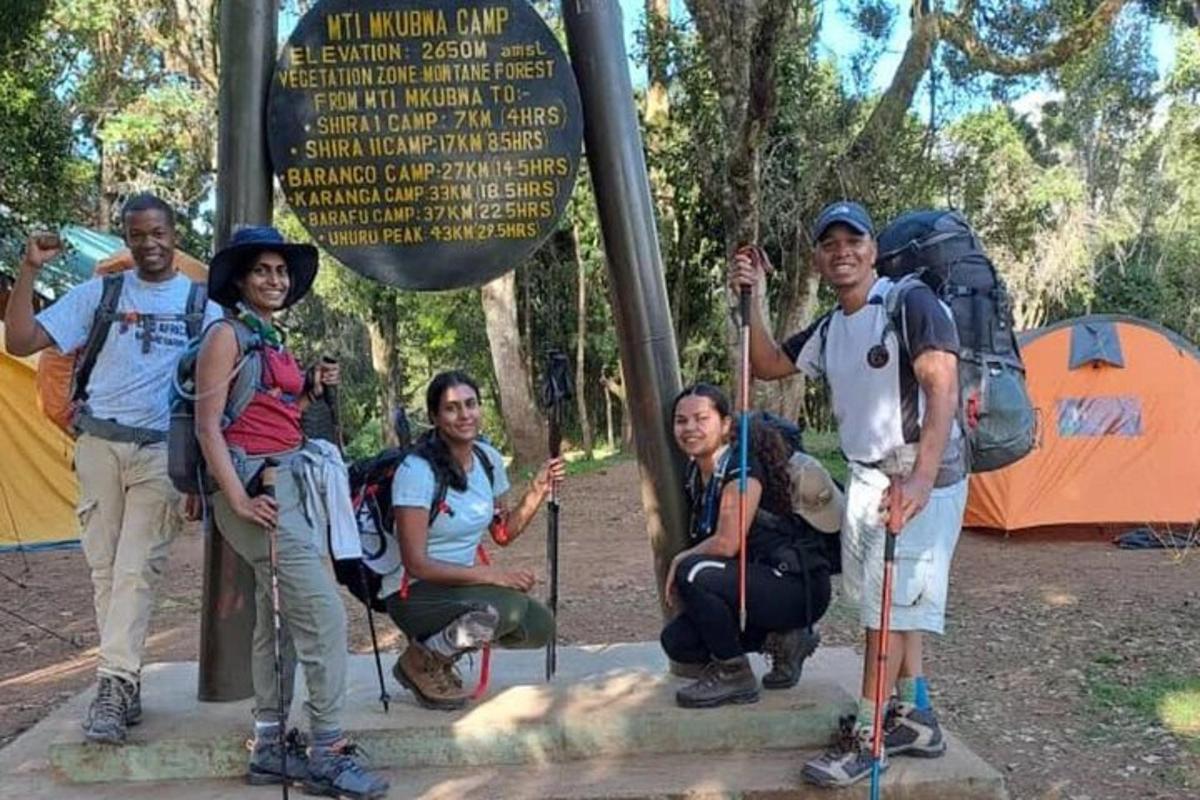 sekumpulan orang berdiri di hadapan papan tanda