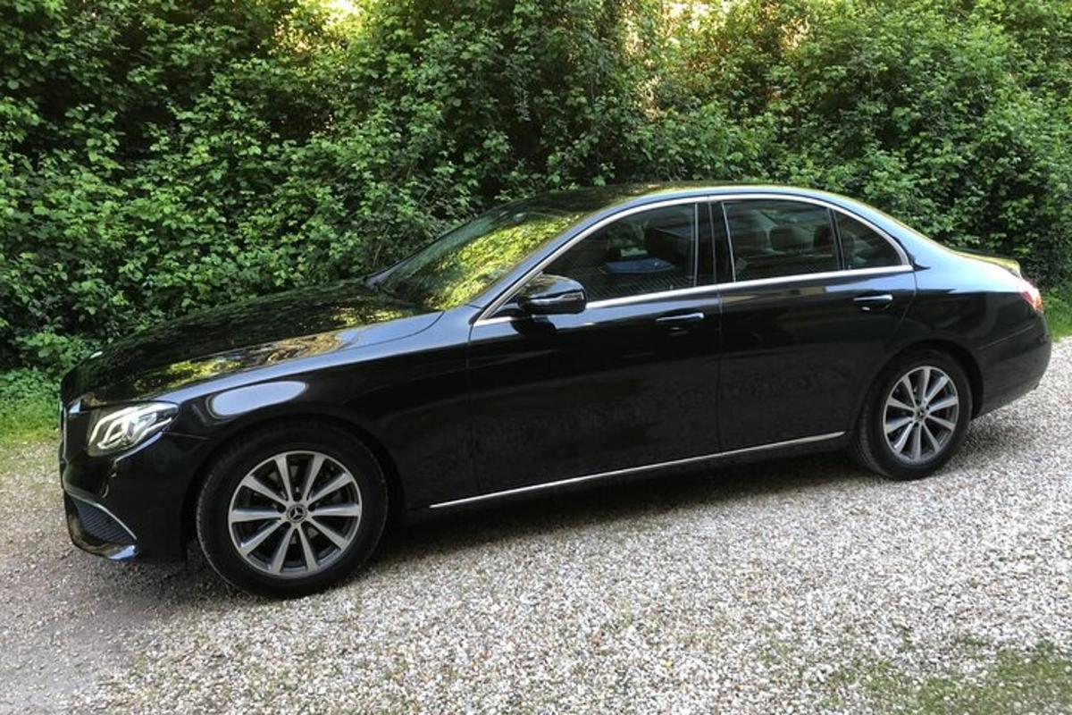 černé auto zaparkované na štěrkové příjezdové cestě