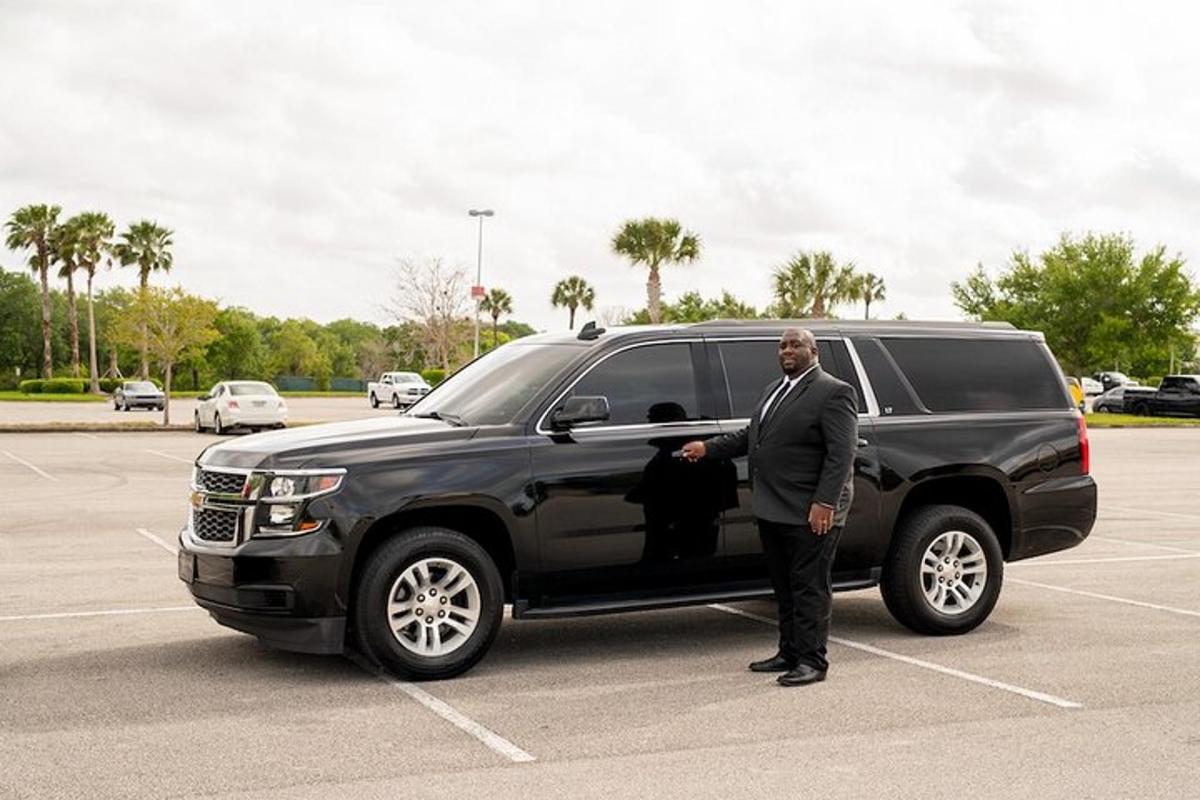 a man in a suit standing next to a black truck