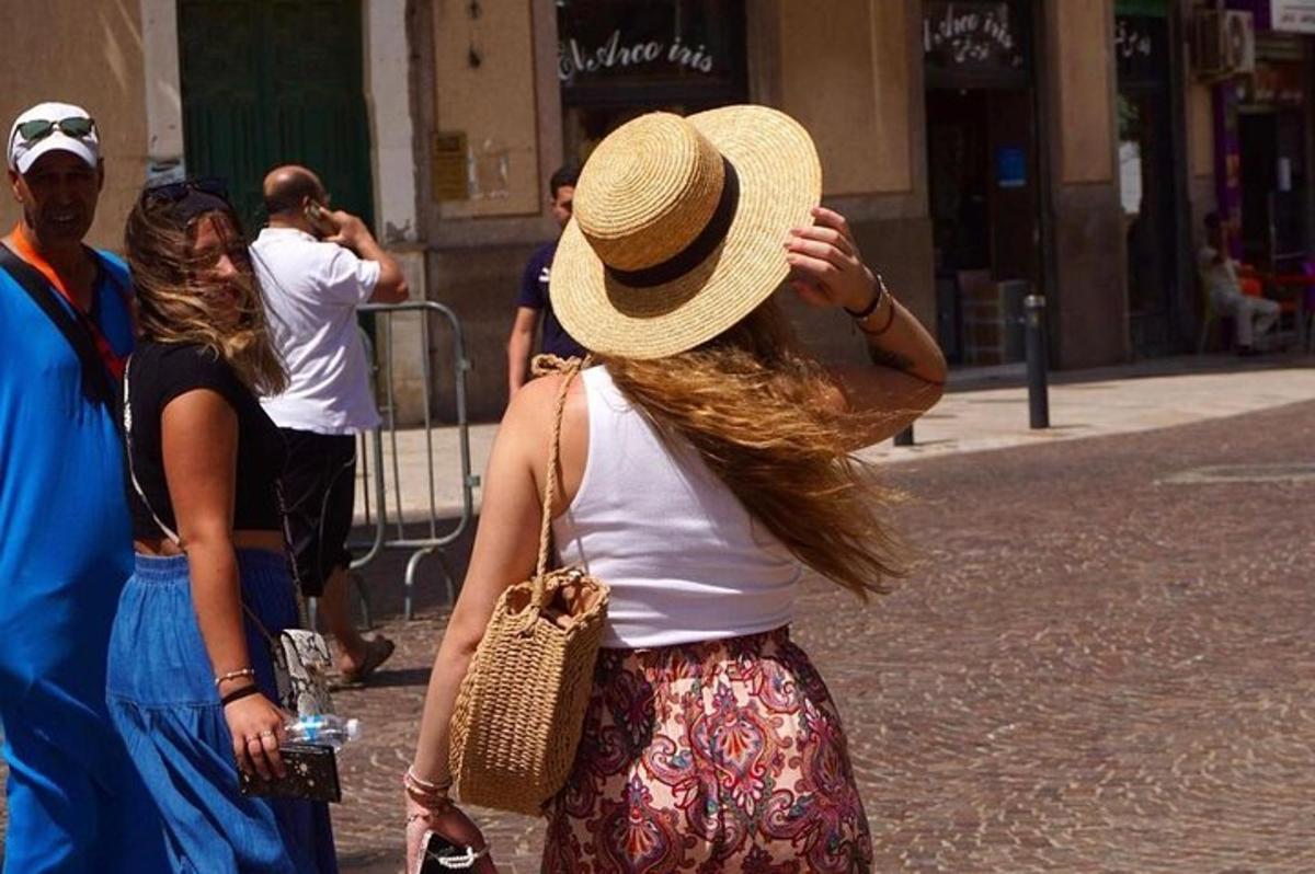 une femme portant un chapeau de paille marchant dans la rue